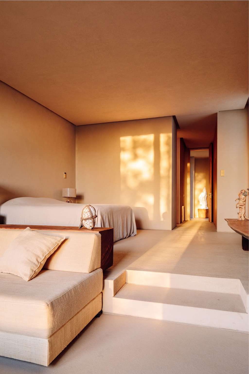 Bedroom with a daybed, steps and a sunlit corridor