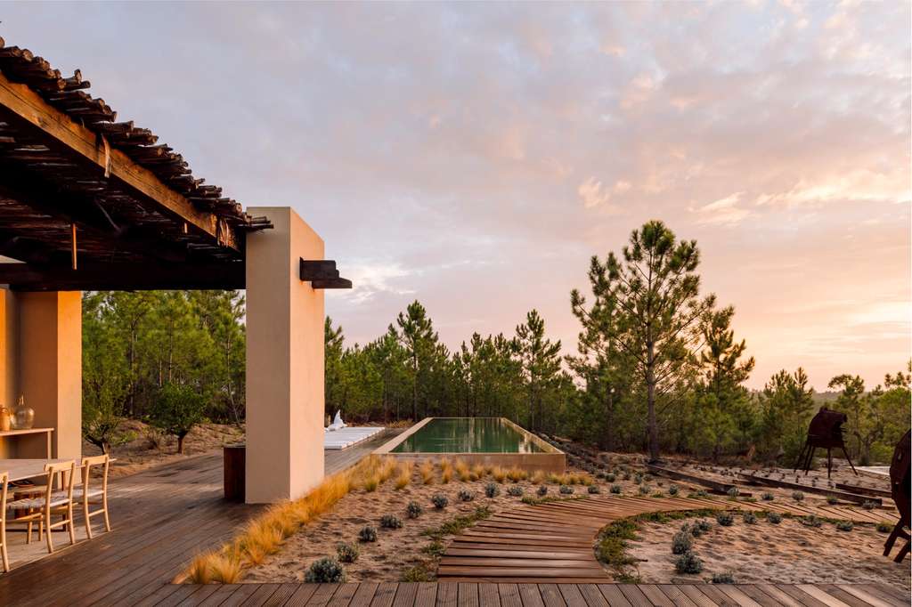 Timber pergola terrace and pool overlooking pines at sunset