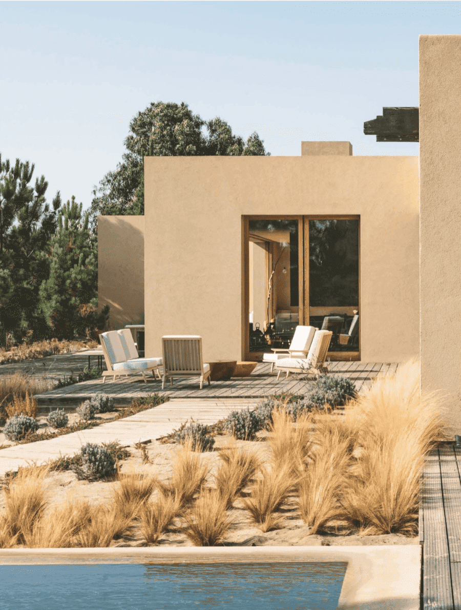 Conde Nast Traveller full-page photo of a sand-colored house with pool and tall grasses
