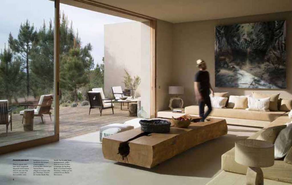 Cote Sud spread of a living room with a large painting and a man walking