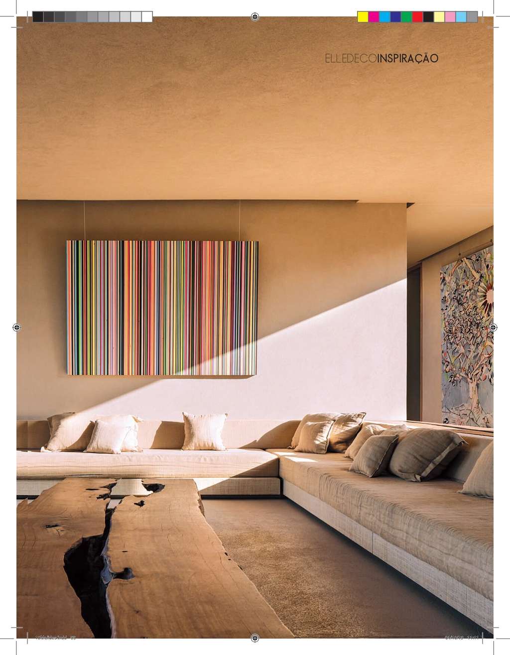 Elle Decoration page with a striped artwork above a long sofa and a tree-trunk table