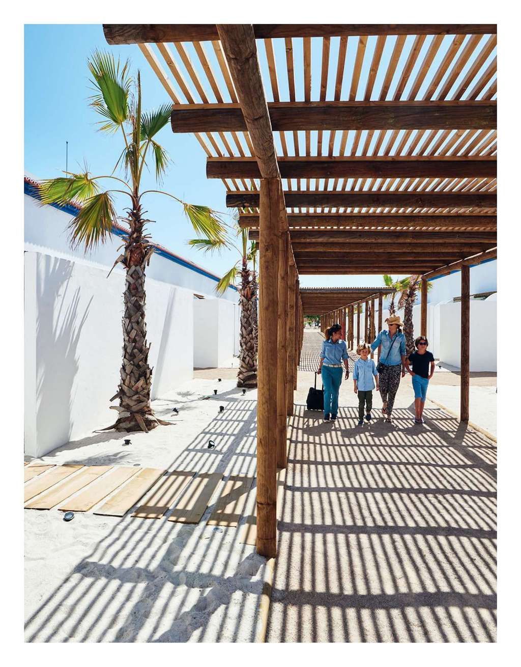 Ideat magazine full-page photo of people walking under a wooden pergola