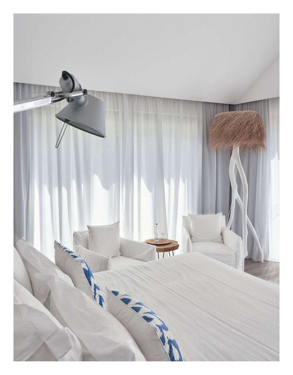 Ideat magazine photo of a white bedroom with curtains and a tall lamp