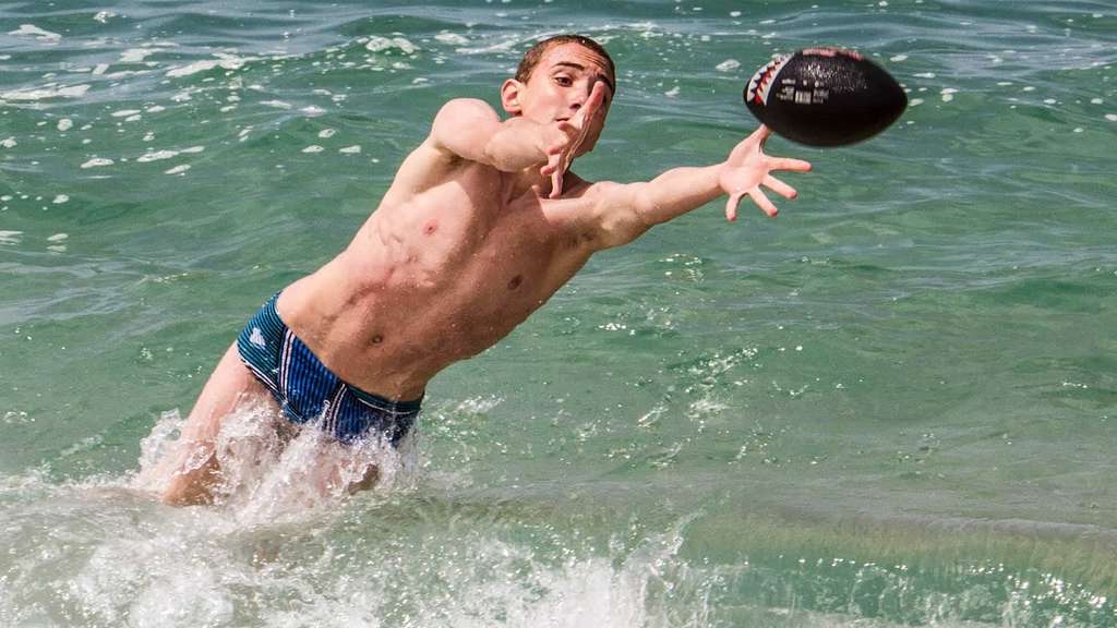 Boy diving for a ball in the sea